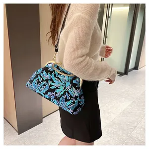 Detailed side view of a sparkling blue sequined evening clutch bag with a gold clasp.