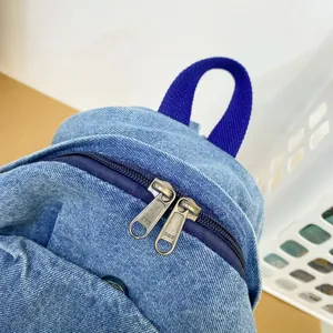 Mochila vintage de mezclilla azul lavado para mujer con detalle de cremallera metálica