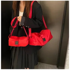 Detalle de bolsos bandolera de tela Oxford rojo vibrante en dos tamaños diferentes.
