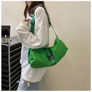 Mujer lleva un gran bolso bandolera Oxford verde neón, ideal para fitness y viajes