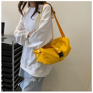 Vista detallada de un gran bolso bandolera amarillo de tela Oxford sobre una modelo