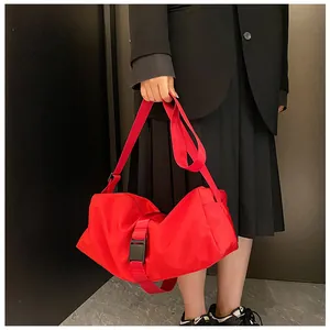 Primer plano de un bolso bandolera rojo de tela Oxford con elegante cierre de hebilla