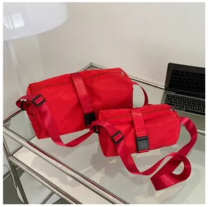 Bolsas de gimnasio rojas de tela Oxford en dos tamaños sobre una mesa de cristal moderna