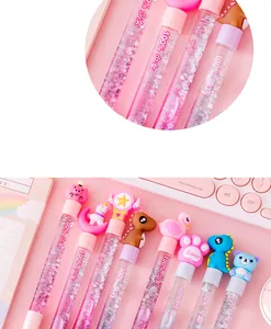 Close-up detail of cute cartoon glitter liquid pens with unicorn and dinosaur toppers.