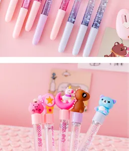 Close-up detail of colorful glitter gel pens featuring various cute cartoon character caps