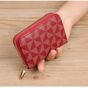Close-up of red and beige geometric pattern card holder with gold zipper detail.