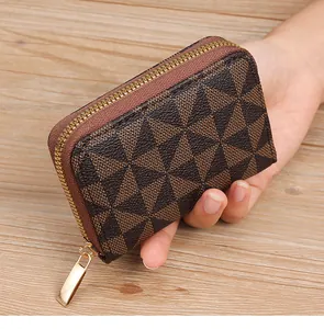 Detailed view of a compact brown star-patterned card holder featuring a gold-tone zipper.