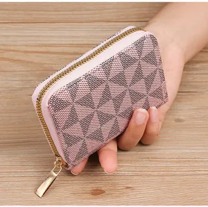 Detailed macro view of a pink geometric pattern card holder with a gold zipper