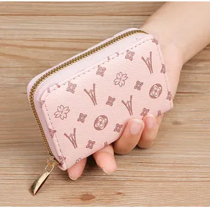 Close-up of pink zippered card holder with elegant monogram and Eiffel Tower print