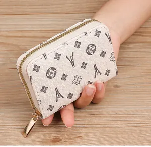 Close-up of a beige faux leather card holder featuring an Eiffel Tower monogram print