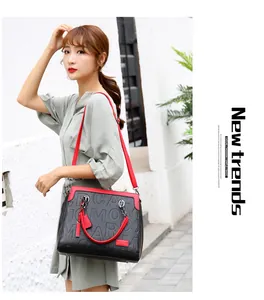 Bolso de mano elegante de gran capacidad con relieve de letras, llevado por modelo.