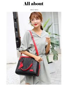 Primer plano de un bolso grande negro y rojo con letras en relieve usado por una modelo