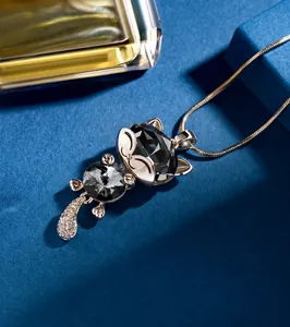 Macro view of crystal cat pendant on elegant snake chain with golden finish