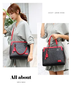 Primer plano de un elegante bolso de mano grabado en negro y rojo llevado por una modelo