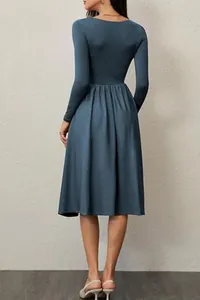 Elegant back view of a solid blue-grey long sleeve midi dress with a pleated A-line skirt.