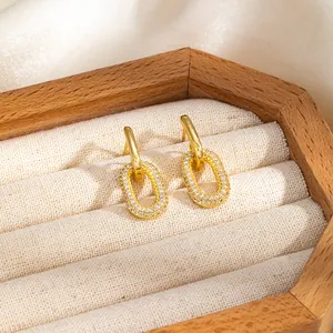 Détail des boucles d'oreilles géométriques plaquées or 16 carats avec zircons