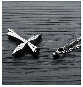 Detailed view of stainless steel winged cross urn pendant showing screw opening mechanism.