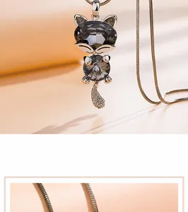 Detail of cute grey crystal cat pendant with shimmering pavé tail on snake chain