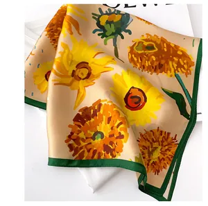 Detail of a mulberry silk square scarf with vibrant sunflower print and green border.