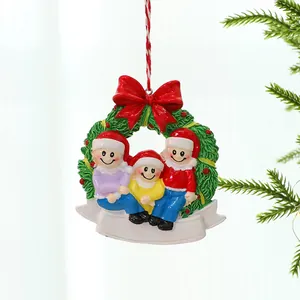 Close-up of a hand-painted resin Christmas ornament featuring a family of three on a tree