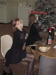 Elegantes schwarzes Netzkleid mit Puffrock, getragen von einem Modell in Weihnachtsdeko