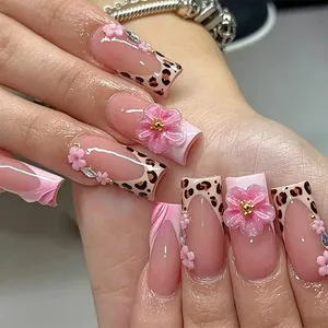 Nahaufnahme von quadratischen Kunstnägeln mit 3D-Blumen und Leoparden-French-Tips.