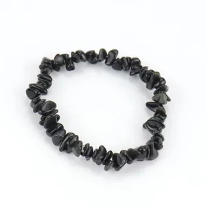 Vista detallada de una pulsera elástica hecha de trozos de piedra natural negra pulida