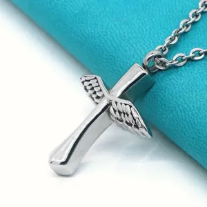 Macro detail of polished stainless steel winged cross pendant for ashes or perfume