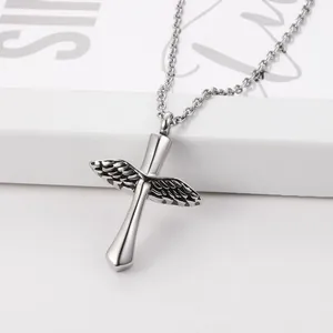 Close-up of a vintage stainless steel winged cross cremation urn necklace pendant