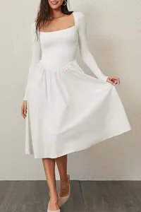 Detailed view of a white long-sleeve dress featuring an elegant square neck and pleated skirt