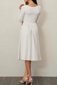 Back view of a white long sleeve pleated midi dress showing elegant waist detailing