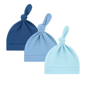 Set mit drei blauen Baby-Knotenmützen aus weichem Strick, ideal für Neugeborene.