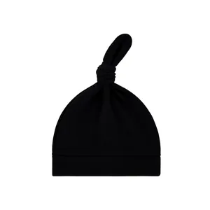 Detailansicht einer weichen, schwarzen Strickmütze für Neugeborene mit Knotendesign.