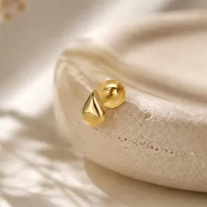 Macro detail of a gold teardrop stud earring featuring a secure flat screw back