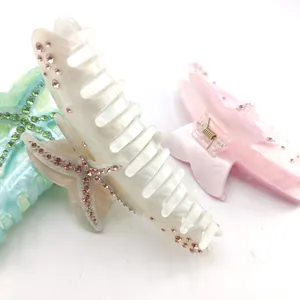 Detailed view of starfish-shaped acetate hair claw clips with marble texture and rhinestones.