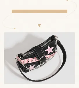 Détail d'un sac à bandoulière noir Y2K avec motifs d'étoiles roses et chaînes en métal.