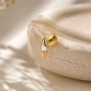 Detailed close-up of a gold rhombus labret stud with a sparkling clear cubic zirconia