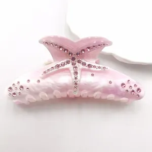 Detailed view of pink starfish rhinestone acetate hair claw clip with marble pattern.