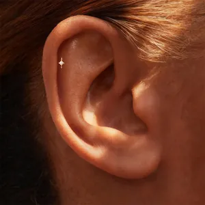Detailed close-up of a gold-plated S925 silver helix stud with a star-shaped diamond design.