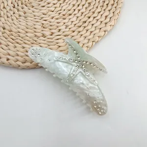 Detailed view of a summer starfish hair claw clip with sparkling rhinestones and marble texture