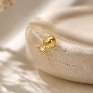 Detail macro view of a gold star-shaped labret stud with a center clear stone.