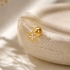 Close-up detail of a gold S925 sterling silver eight-pointed star piercing ear stud.