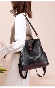 Close-up of a multi-purpose black PU leather backpack with burgundy trim on a model