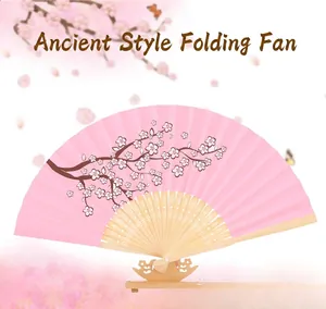Pink folding fan with cherry blossom pattern on a decorative wooden stand