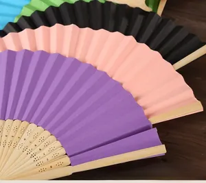 Detailed view of stacked colorful blank paper folding fans with decorative bamboo ribs