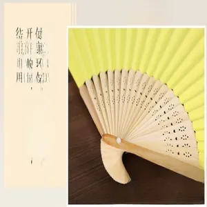 Detailed macro view showing the 21 hollow bamboo ribs of this 6-inch yellow paper folding fan