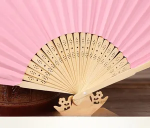 Close-up of a pink folding paper fan with natural bamboo ribs, perfect for DIY painting