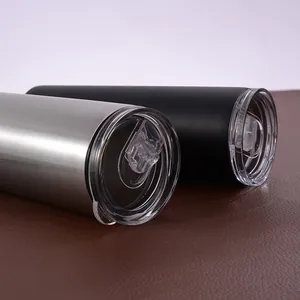 Gros plan de gobelets minces 20oz en inox avec couvercles clairs sur cuir.
