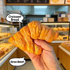 Vista macro de un juguete blando de cruasán realista siendo apretado en una panadería