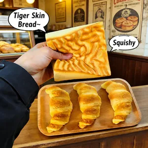 Close-up of hand squeezing tiger-skin bread squishy toy to show soft slow rebound texture.